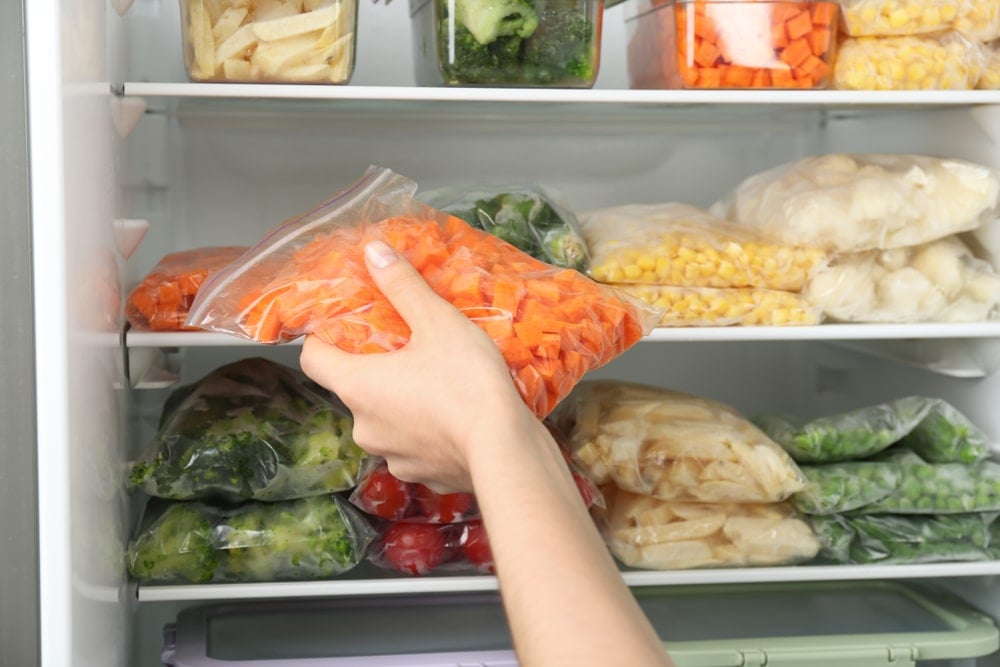 把各种食物装在密封袋里放进冰箱的女人。
