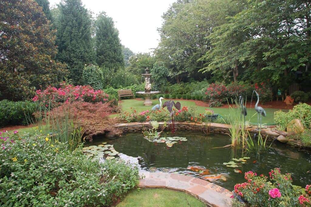 大型花园在池塘和喷泉周围工作。这座池塘看起来很棒，在这个梦幻般的大型花园里享有可爱的植物群。
