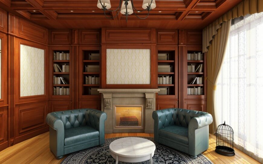 一个经典的家庭图书馆，内置书架和壁炉以及优雅的蓝色座椅设置在硬木地板上，顶部是一个漂亮的地毯。