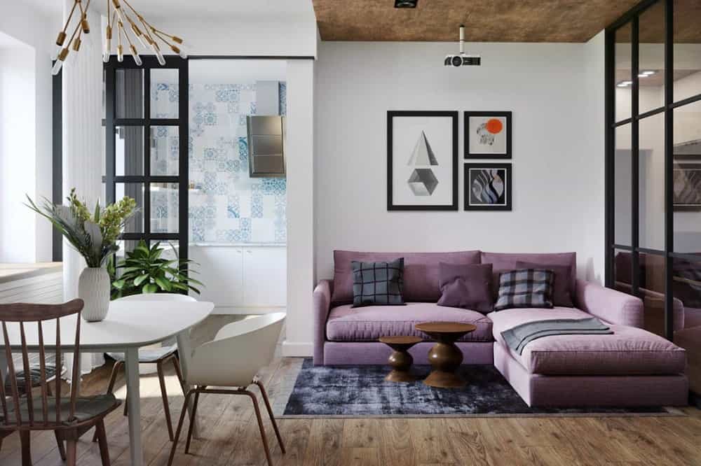 这是公寓的客厅，紫色的大l型组合沙发靠近白色的餐厅，几步之遥。这是Vagon建筑事务所设计的。