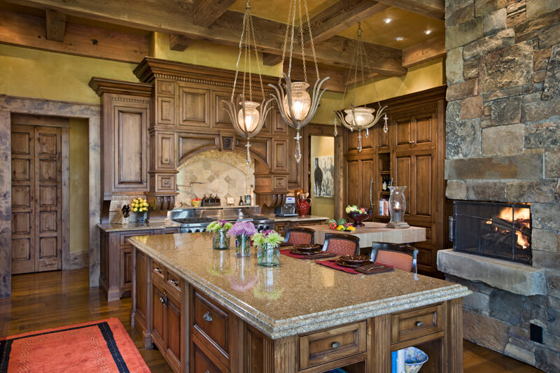 岛的厨房视图酒吧风格的座位，壁炉，和广泛的木制橱柜。建筑设计师:Schlauch botcher Construction Interior Design: <a href= 