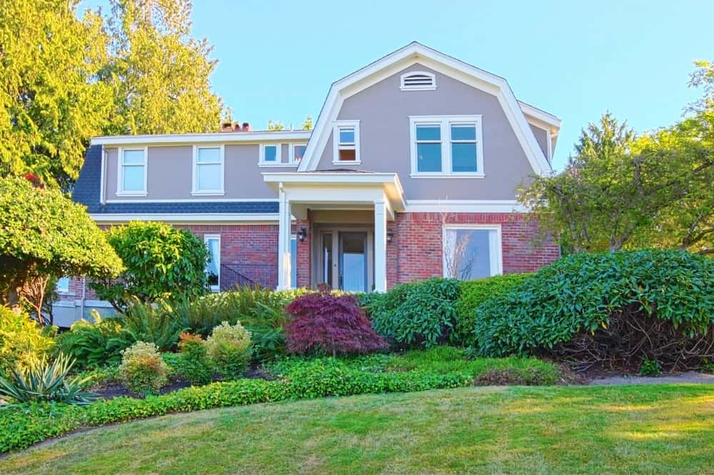 这座玫瑰色的房子隐藏在绿色的景观中，像一朵鲜花一样在郁郁葱葱的绿色环境中突出。