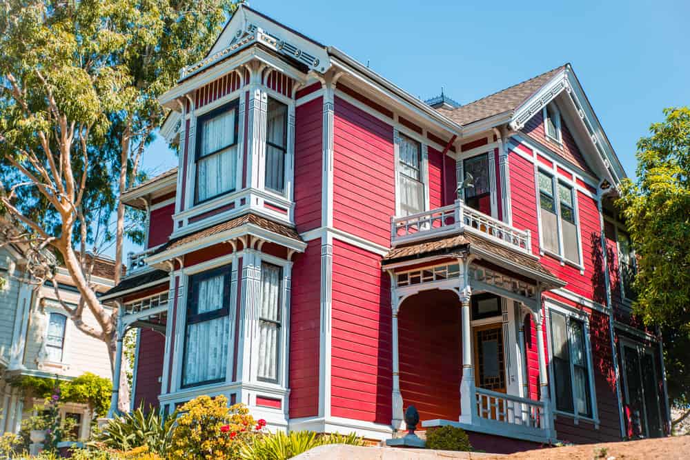 明亮的红色维多利亚时代的房子，有大型着名的前窗口的两个楼层。