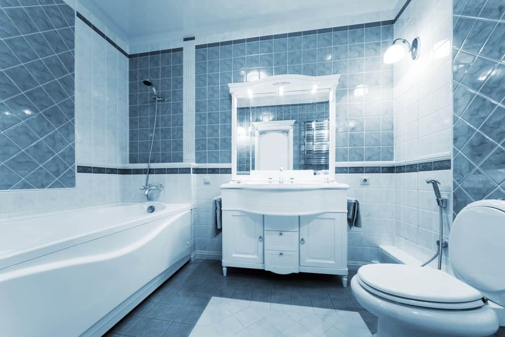 漂亮的主浴室，墙壁和地板上铺着蓝色瓷砖。