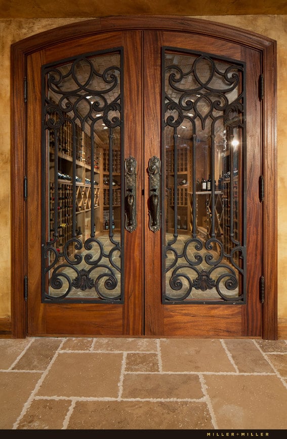 通往酒窖的门和前门一样，都是桃花心木的，但都镶着设计复杂的铁板。