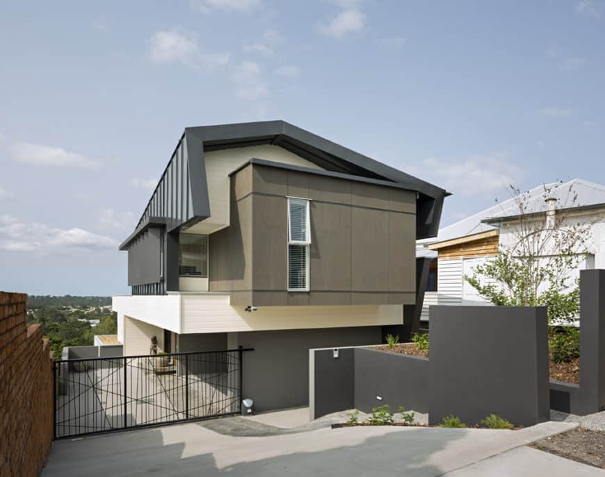 一个现代家，具有灰色的外观，带门和漂亮的车库的车道。