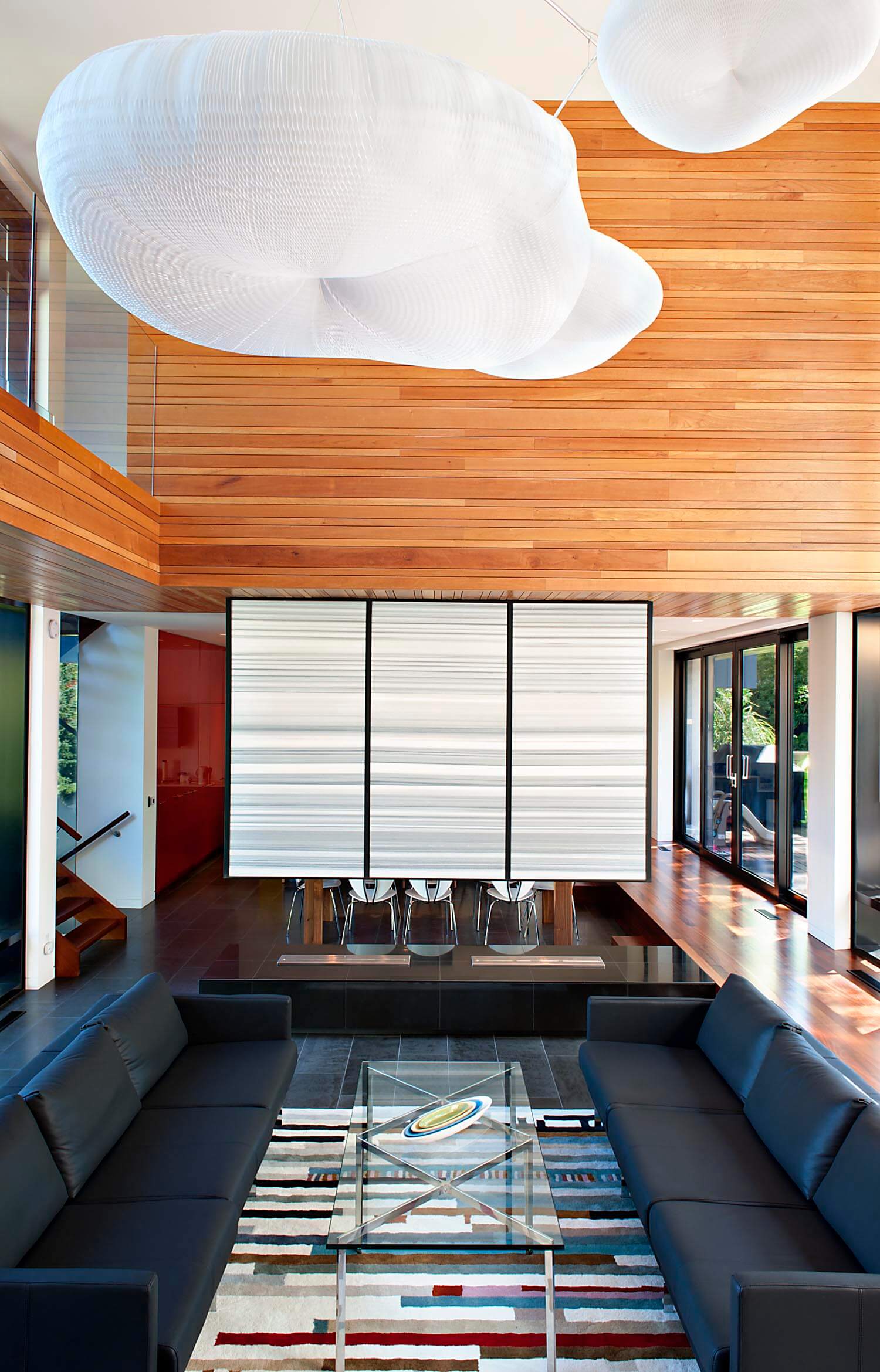 可以直接看到座位区:低矮的皮革沙发与玻璃和抛光的金属咖啡桌相接，白色的分隔墙将用餐空间分隔开来。
