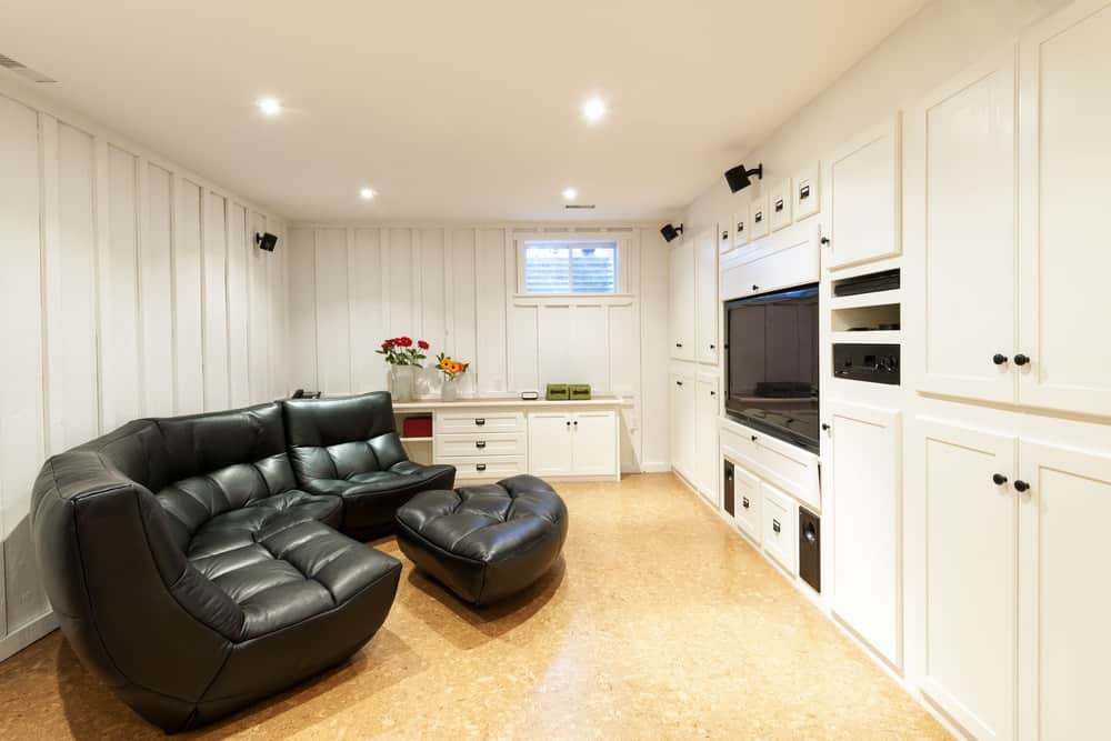 这是一个舒适和舒适的地下室，白色的墙壁和轻硬木地板。